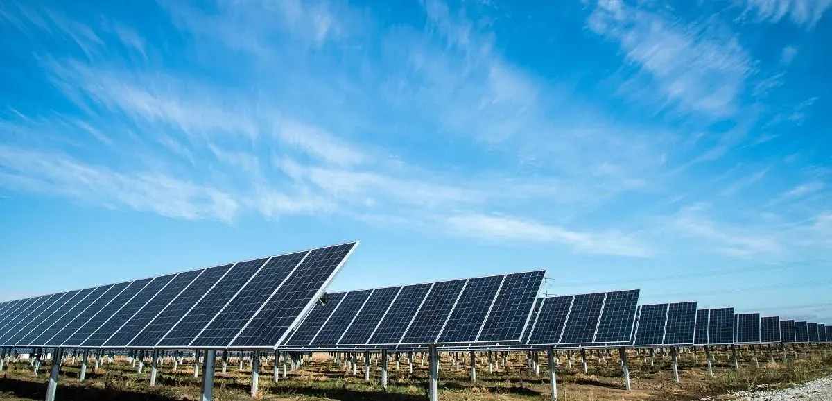 Rows of ground-mounted solar panels in an open landscape